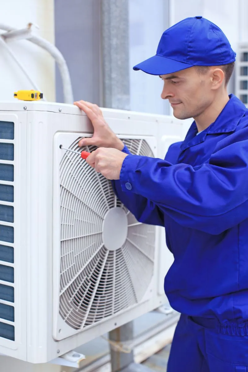 male technician cleaning air conditioning unit