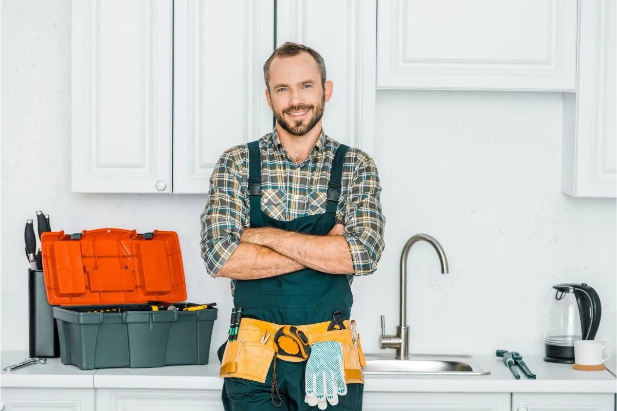 smiling plumber standing with tools for residential plumbing service