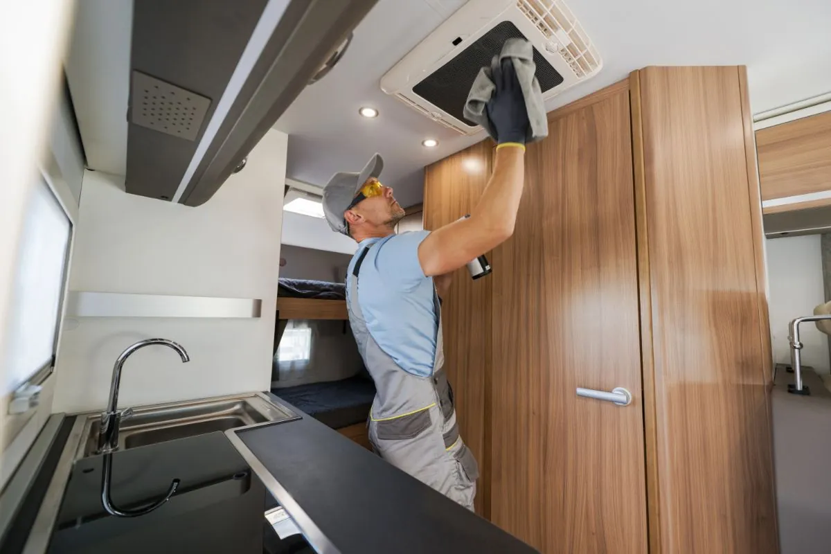 technician cleaning ceiling mounted air conditioning unit