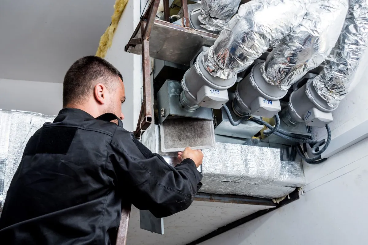 technician cleaning ventilation filter HVAC system