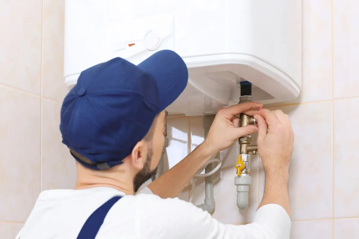 plumber installing water heater in bathroom